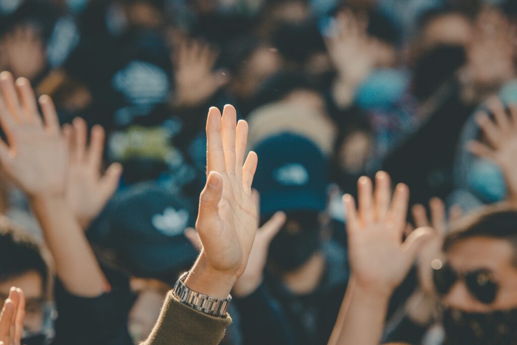 Hands raised in a crowd of people.