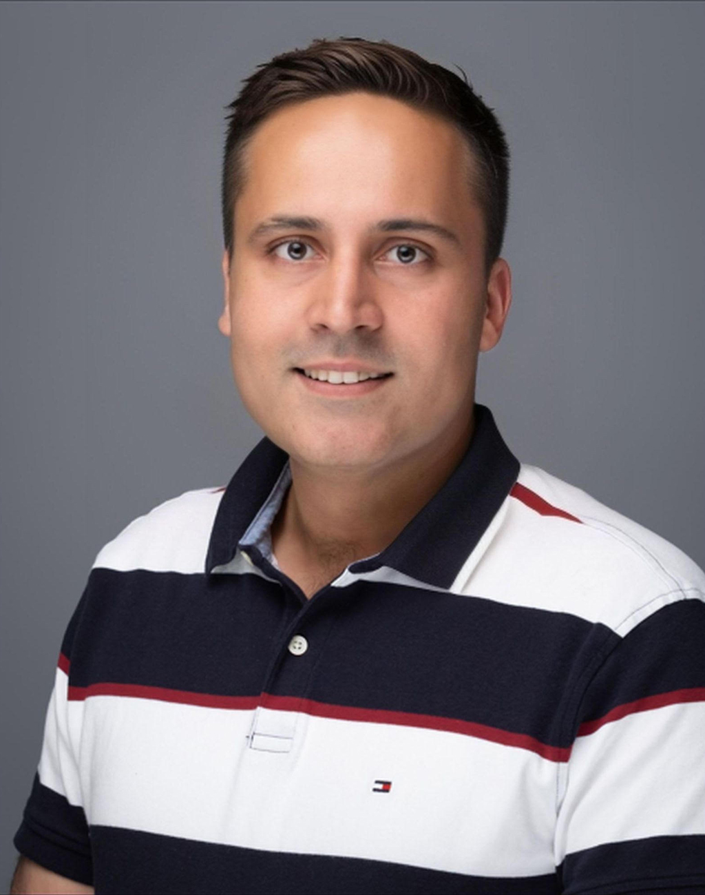 Professional headshot of Rahul Jain, who is wearing a striped collared shirt and has short brown hair.